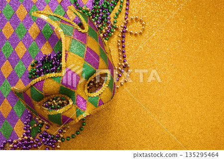 Mardi gras carnival mask with colorful beads on glitter Mardi gras carnival mask with colorful beads on glitter 135295464