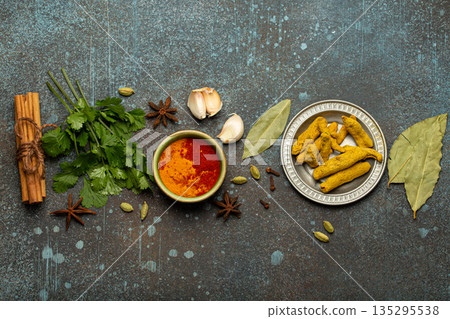 Various Indian spices and herbs arranged on a rustic background . 135295538