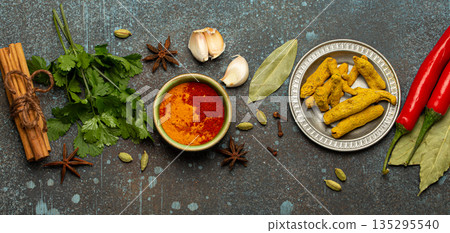 Various Indian spices and herbs arranged on a rustic background . 135295540