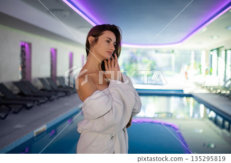 Relaxed dark-haired woman in the swimming pool at spa salon Relaxed dark-haired woman in the swimming pool at spa salon 135295819