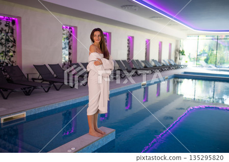 Relaxed dark-haired woman in the swimming pool at spa salon Relaxed dark-haired woman in the swimming pool at spa salon 135295820