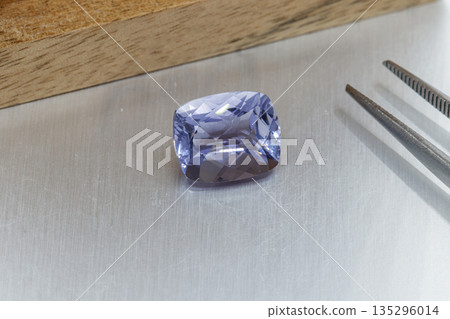 macro mineral faceted stone Cordierite on a gray background macro mineral faceted stone Cordierite on a gray background 135296014