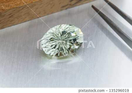 macro mineral faceted stone cut Beryl on a gray background macro mineral faceted stone cut Beryl on a gray background 135296019