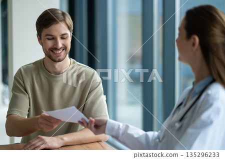 Male patient getting medicine prescription from the doctor in clinic Male patient getting medicine prescription from the doctor in clinic 135296233