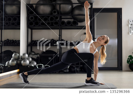 Blonde young woman exercising in the gym and looking determined 135296366