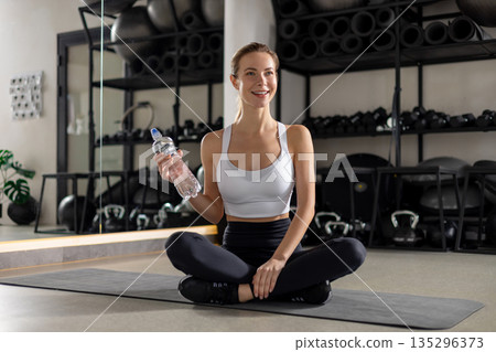 Blonde young woman in the gym looking contented Blonde young woman in the gym looking contented 135296373