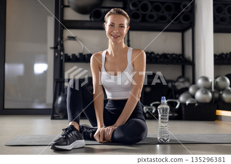 Blonde young woman in the gym looking contented 135296381