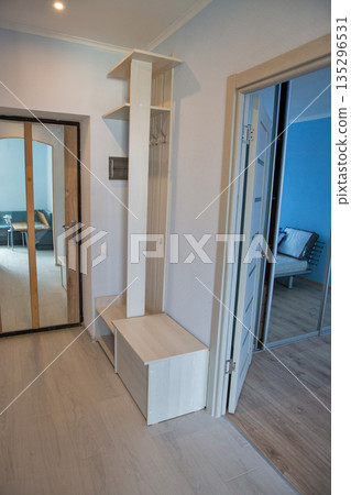 Modern hallway interior with white storage unit and mirror doors. Modern hallway interior with white storage unit and mirror doors. 135296531