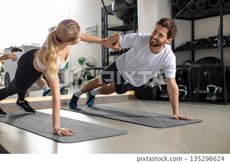 Man and woman exercising together and looking contented and determined 135296624