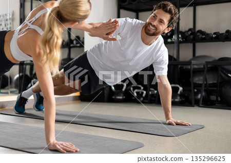 Man and woman exercising together and looking contented and determined Man and woman exercising together and looking contented and determined 135296625