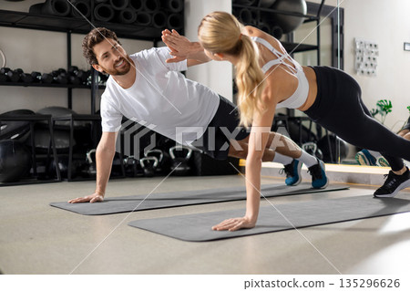 Man and woman exercising together and looking contented and determined 135296626