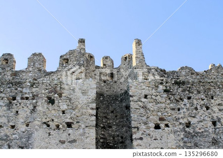 Detailed view of the ancient merlons and stone fortifications of the Rocca di Lonato del Garda, Brescia province, Italy, under a clear sky. Detailed view of the ancient merlons and stone fortifications of the Rocca di Lonato del Garda, Brescia province, Italy, under a clear sky. 135296680