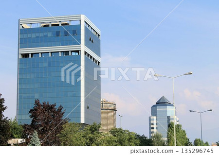 Contemporary office buildings with blue glass facades in the Brescia Due (Brescia 2) financial district. Modern urban architecture under a clear sky in Lombardy. Contemporary office buildings with blue glass facades in the Brescia Due (Brescia 2) financial district. Modern urban architecture under a clear sky in Lombardy. 135296745