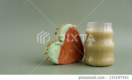 Green tea Matcha latte cappuccino beverage Morning breakfast gift idea Heart shaped pistachio croissant on green background with copy space. Puff pastry trendy sweet dessert bakery. Creamy dough 135297581