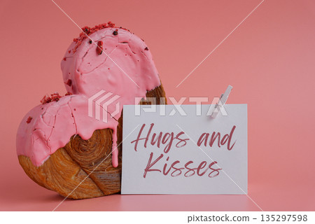 Birthday Valentine's day HUGS AND KISSES wishes saying caption on greeting card Delightful heartshaped pastry croissant treat, beautifully topped with colorful frosting galore. Copy space. Food 135297598