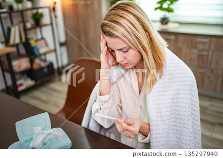 Feeling unwell at home while checking temperature with worry 135297940
