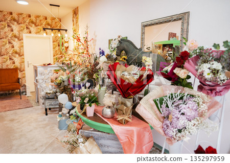 Brightly colored floral arrangements fill a cheerful boutique adorned with playful decor Brightly colored floral arrangements fill a cheerful boutique adorned with playful decor 135297959