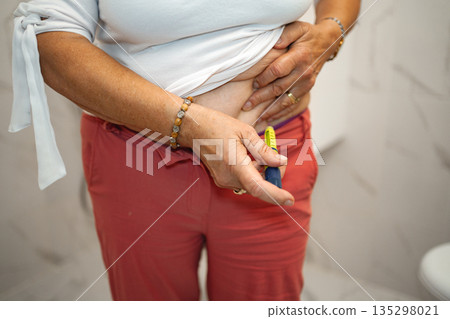 Managing diabetes with careful monitoring in a cozy bathroom setting 135298021