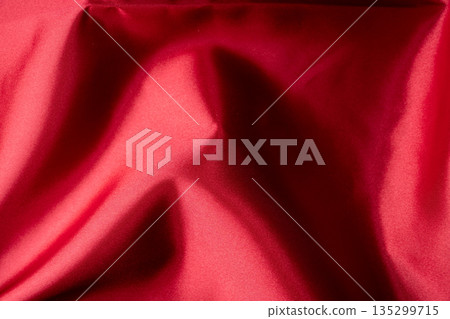 A textured material that captures the luster and shadows of red fabric A textured material that captures the luster and shadows of red fabric 135299715