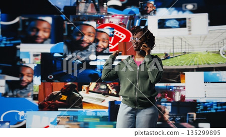 Young woman uses smartphone to do telephone call with mate, discussing online videos. Teenager uses phone to call friend and talk about shared media consumption, colorful multimedia backdrop, camera A Young woman uses smartphone to do telephone call with mate, discussing online videos. Teenager uses phone to call friend and talk about shared media consumption, colorful multimedia backdrop, camera A 135299895