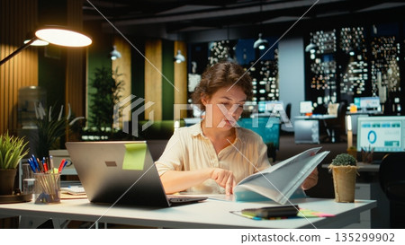 Engaged executive manager researching market data and developing strategy to meet business goals, using spreadsheets for proofreading. Late night work in a multinational company. Camera B. Engaged executive manager researching market data and developing strategy to meet business goals, using spreadsheets for proofreading. Late night work in a multinational company. Camera B. 135299902