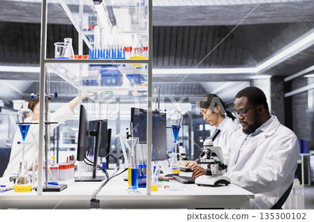 Laboratory scientist using computer software to process DNA patient data for clinical research. Research facility specialist uses PC program to do lab genetic analysis diagnostics Laboratory scientist using computer software to process DNA patient data for clinical research. Research facility specialist uses PC program to do lab genetic analysis diagnostics 135300102
