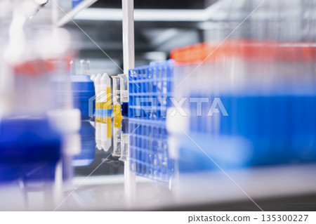 Close up of reagents in vials ready to be used for experimental analysis inside modern research center. Colorful chemical solutions inside test tubes rack on laboratory shelf 135300227