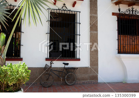 Rusty bike at the beautiful colonial streets of the Heritage Town of Santa Cruz de Mompox in Colombia. 135300399