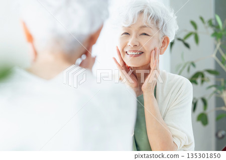 Senior woman feeling the moisture in her skin 135301850