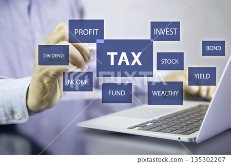 person interacts with a digital interface showing "TAX" surrounded by financial keywords like "PROFIT", "INVEST", and "INCOME," representing financial planning and management. 135302207