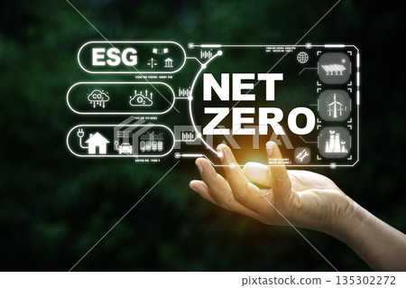 hand holding a digital interface with "ESG" and "NET ZERO" icons, illustrating a comprehensive approach to environmental, social, and corporate governance goals. 135302272