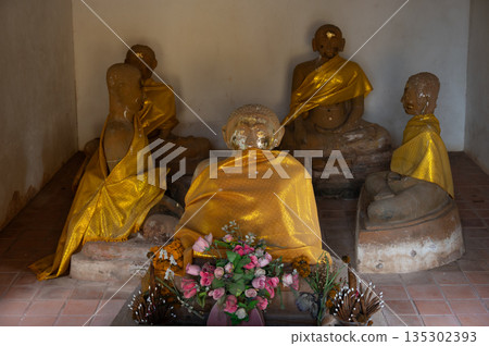 An old Buddhist sculptures decorated inside small Viharn in Wat Phra Fang temple in Uttaradit province of Thailand. Built since 1700 B.E. during Sukhothai period. An old Buddhist sculptures decorated inside small Viharn in Wat Phra Fang temple in Uttaradit province of Thailand. Built since 1700 B.E. during Sukhothai period. 135302393