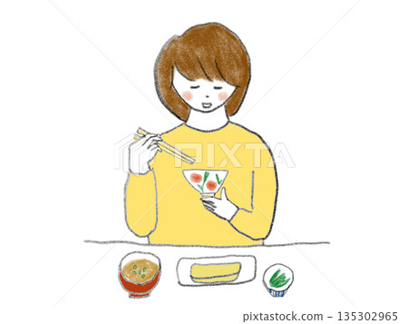 一位女士正在吃日本料理 135302965