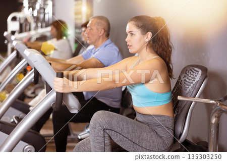 Woman warming up on bikes in spin class at gym 135303250