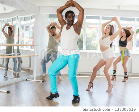 Group dance class in bright studio displaying elegance and sensuality, with every move exuding modern grace 135303539