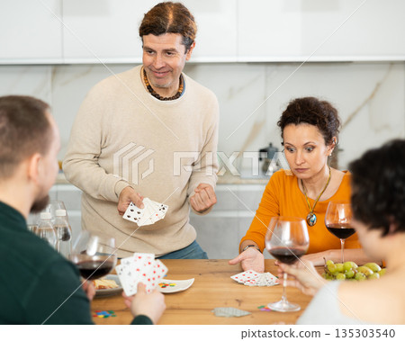 Two married couples playing card game poker 135303540