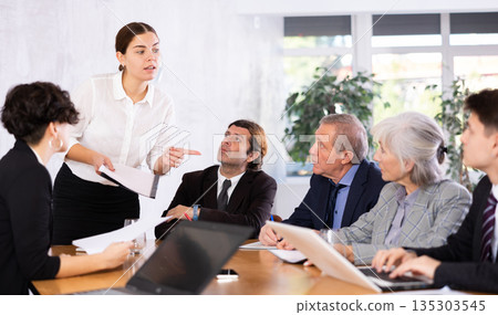 Female corporate worker expressively speaking at team briefing, disagreeing, blaming others Female corporate worker expressively speaking at team briefing, disagreeing, blaming others 135303545