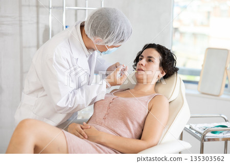 Woman getting procedure of injection contouring and for facial correction in clinic Woman getting procedure of injection contouring and for facial correction in clinic 135303562