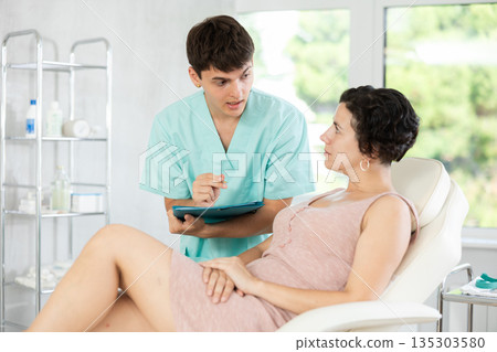 Doctor cosmetologist writes down the complaints of female patient in cosmetology clinic Doctor cosmetologist writes down the complaints of female patient in cosmetology clinic 135303580