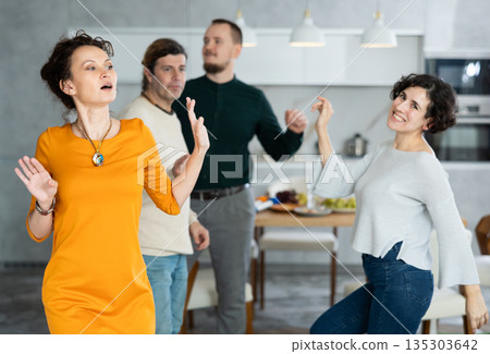 Men and women doing couple dancing during house party. 135303642