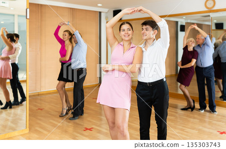 Young happy couple performing a paired dance in ballroom 135303743