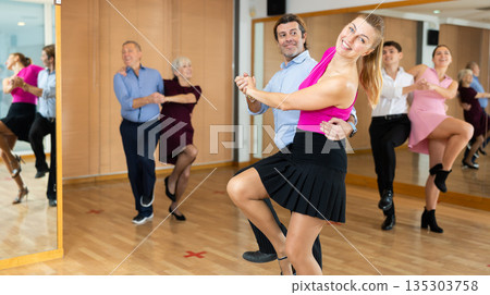 Woman and man enjoying rock and roll dance in studio 135303758