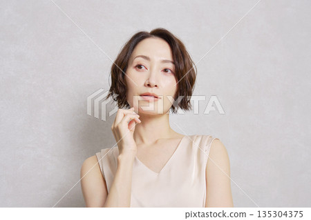 Middle-aged woman portrait gray background Middle-aged woman portrait gray background 135304375