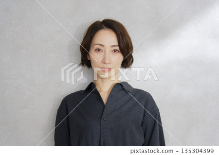 Middle-aged woman portrait on gray background Middle-aged woman portrait on gray background 135304399
