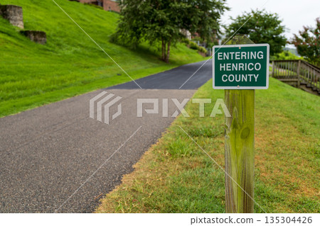 A green sign on a wooden post that says "Entering Henrico County." 135304426