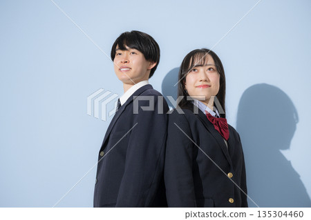 High school boys and girls lined up against a light blue background. A high school girl and a high school boy look up at their future and goals, and do their best to pass the entrance exams. High school boys and girls lined up against a light blue background. A high school girl and a high school boy look up at their future and goals, and do their best to pass the entrance exams. 135304460