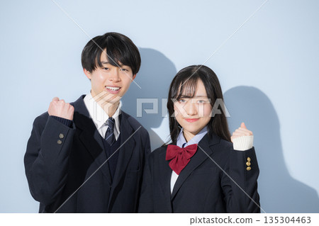 一群高中男生和女生並肩站在淺藍色背景前。一名高中女生和一名高中男生看著鏡頭,握拳慶祝。 一群高中男生和女生並肩站在淺藍色背景前。一名高中女生和一名高中男生看著鏡頭,握拳慶祝。 135304463
