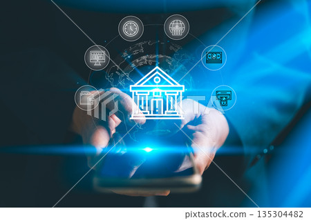 Digital banking concept with hands using smartphone and glowing bank icon, showing mobile payments, online transactions, global finance network and secure fintech services for customers worldwide. Digital banking concept with hands using smartphone and glowing bank icon, showing mobile payments, online transactions, global finance network and secure fintech services for customers worldwide. 135304482