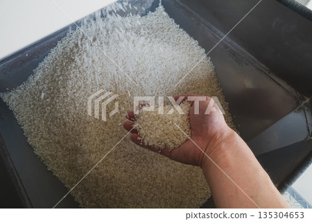 Rice being polished using a coin-operated rice polishing machine Rice being polished using a coin-operated rice polishing machine 135304653