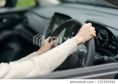 駕駛一輛車的女人的手 135305492